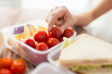 close up of woman with food in plastic container