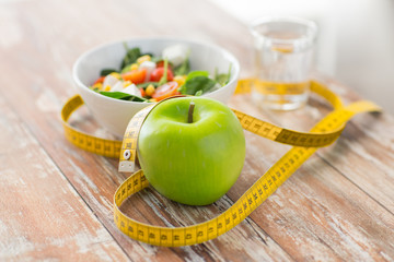 close up of green apple and measuring tape - obrazy, fototapety, plakaty