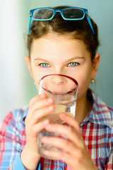 Girl drinking water - child with a glass of water 