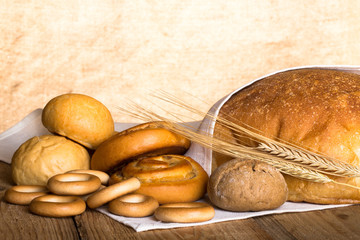 Bread assortment and wheat ears on an old wooden table
