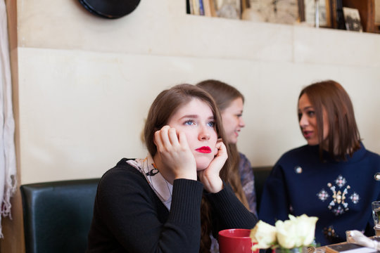 young woman ignored by her friends in cafeteria
