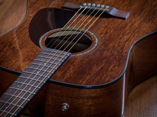 Acoustic guitar lying on the wooden floor