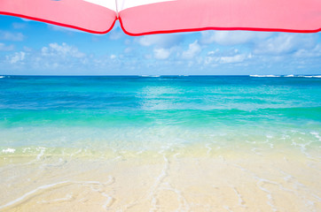 Beach umbrella next to ocean background