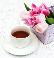 Fototapeta na wymiar Cup of tea and pink tulips