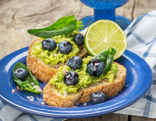 Avocado sandwich and blueberry on the wooden background