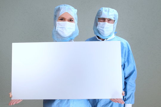 Zwei OP &Auml;rzte mit leerem Schild in der Hand