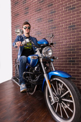 Obraz na płótnie Canvas Handsome Guy Sitting on a Blue Sports Motorbike