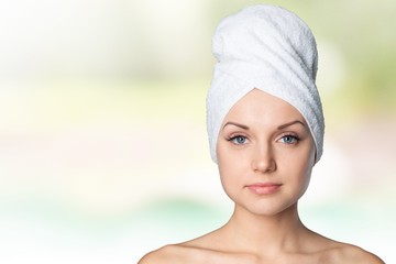 Adults. Beautiful woman with a towel on his head on a white