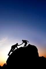 Silhouette of helping hand between two climber