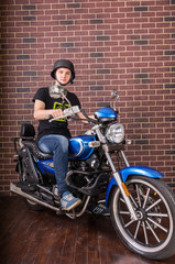 Obraz na płótnie Canvas Portrait of Young Man on Motorcycle by Brick Wall