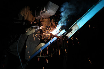Welding operator welds metal constructions