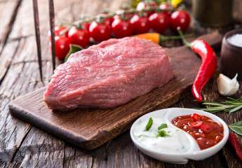 Raw beef steak on wooden table