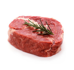 Raw ribeye steak garnished with sprig of rosemary