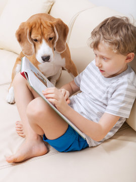 Boy reading for his dog at home