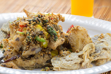 grilled Black Pepper Fish in white plate on wooden table