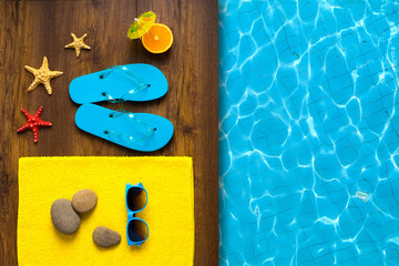 Flip flop shoes and sunglasses of young people near hotel pool