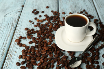 Cup of coffee with beans on color rustic wooden background