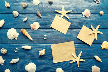 Card blanks with sea stars and shells on wooden background