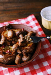 Baked potatoes with mushrooms in bowl and sauce