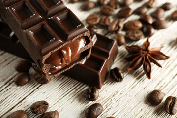 Stuffed chocolate with coffee beans on wooden table, closeup