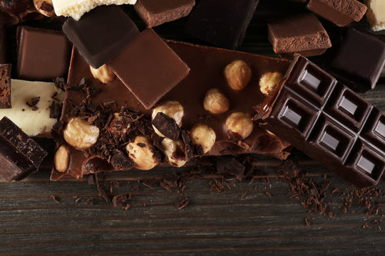 Set of chocolate with hazelnut on wooden table, closeup