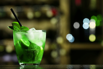 Glass of cocktail on bar background