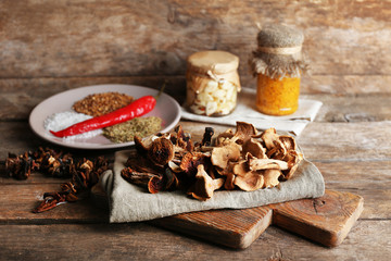 Fototapeta premium Dried mushrooms with spices on wooden background