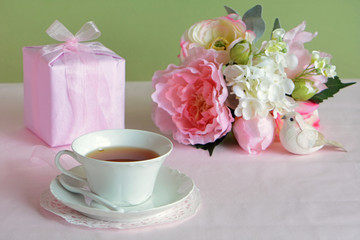 Lovely flowers with gift and cup of tea