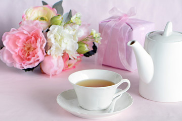 Lovely flowers with gift and cup of tea
