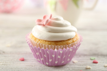 Delicious cupcake on table on light background