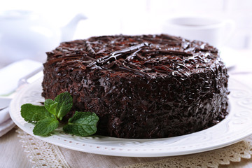 Tasty chocolate cake with cup of tea on table close up