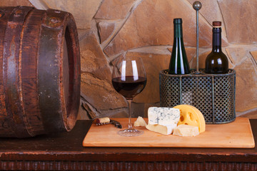 Glass and bottle of wine, cheese and prosciutto