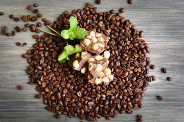 Chocolate with mint and coffee beans on wooden table, top view