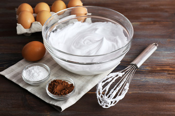 Whipped egg whites for cream on wooden background