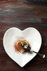 Tasty panna cotta dessert on plate, on wooden table