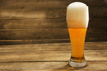 Glass of beer on wooden background