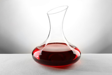 Glass carafe of wine on light background