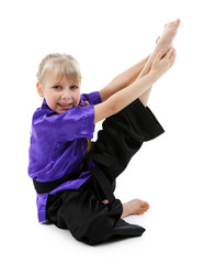 Little girl in kimono doing exercises isolated on white