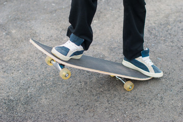 Fototapeta na wymiar Skateboarder rides on the pavement.