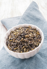 Dried green leaves of tea in a bowl