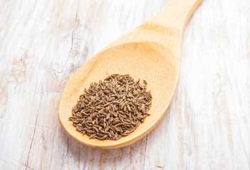 cumin on bamboo wooden spoon
