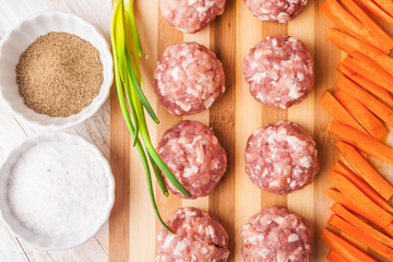 raw meatballs with minced meat on kitchen boardl