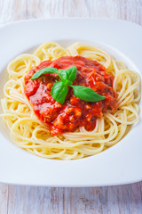 spaghetti bolognese in white bowl on wooden table