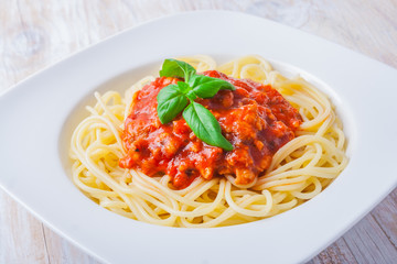 spaghetti bolognese in white bowl on wooden table