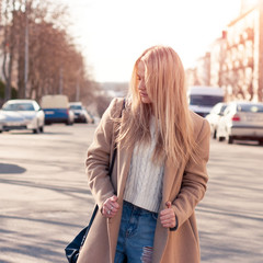 Amazing blonde girl walking alone on the road