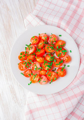 tomatoes with chives on white plate