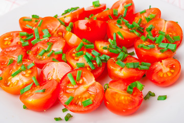 tomatoes with chives on white plate