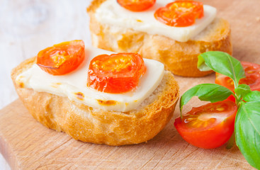 toasts with feta cheese and tomatoes on the kitchen board