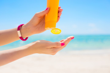 Woman pouring sunscreen in hand
