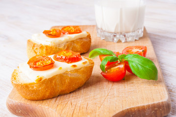 toasts with feta cheese and tomatoes on the kitchen board